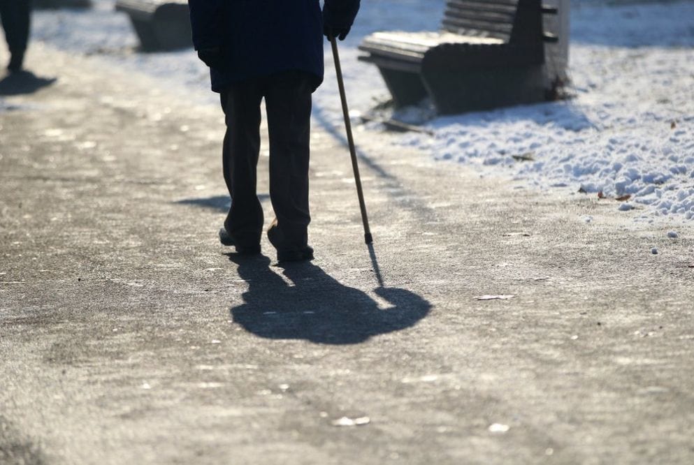 άνδρας με μπαστούνι, χιονισμένος δρόμος