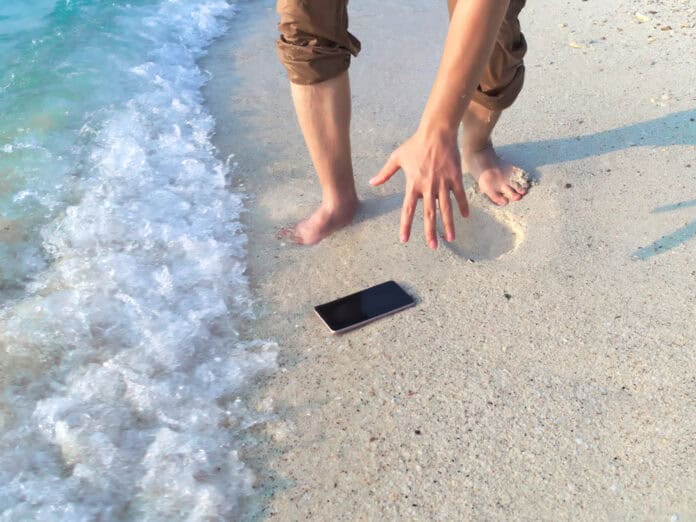 smartphone on the beach, travel insurance, source: Shutterstock