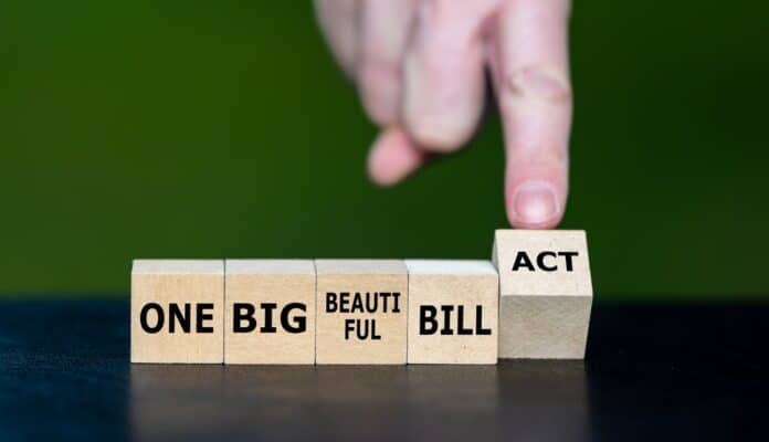 Hand turning "One Big Beautiful Bill Act" cubes, image source: Shutterstock