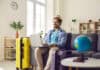 traveler at home with laptop and globe, source: Shutterstock