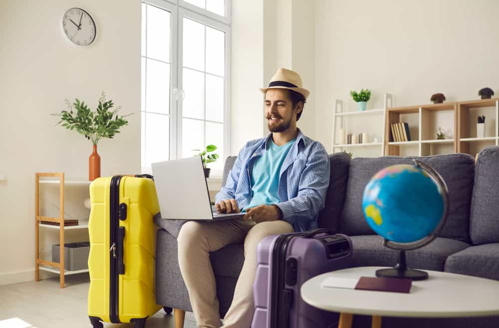 traveler at home with laptop and globe, source: Shutterstock