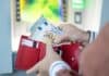 Person putting money from ATM in wallet, source: Shutterstock