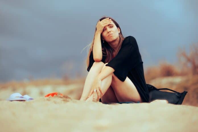 Unhappy woman at the beach, source: Shutterstock