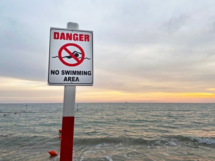 "No swimming" beach sign, source: Shutterstock