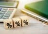 Percentage sign on wooden cubes, business background, source: Shutterstock