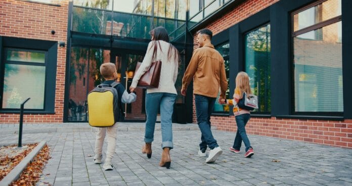 Camera,View,From,Behind,Of,Caucasian,Family,Walking,Together,Towards Parents and children going to school, source: Shutterstock