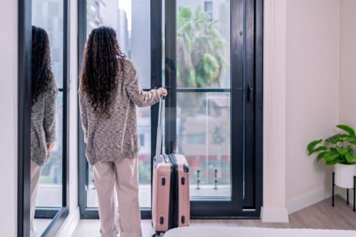 Digital,Nomad,With,Rolling,Suitcase,Opening,Balcony,Door,In,Airbnb Tourist with suitcase in rented appartment, source: Shutterstock