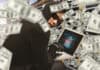 Hacker with laptop and money, source: Shutterstock