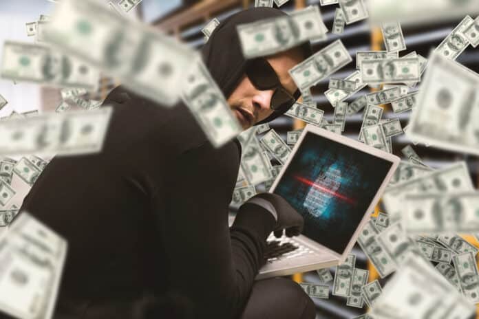 Hacker with laptop and money, source: Shutterstock