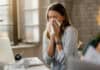 sick woman working at laptop, flu concept