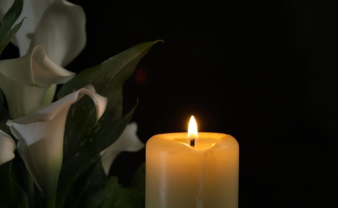 Close-up,View,Of,A,Single,Burning,Wax,Candle,Next,To Death concept with candle, source: Shutterstock