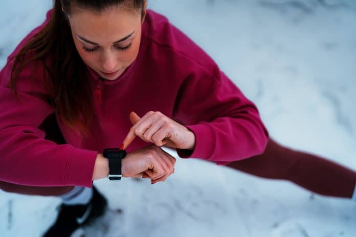 Winter fitness in snow, woman with fitness tracker, source: Shutterstock