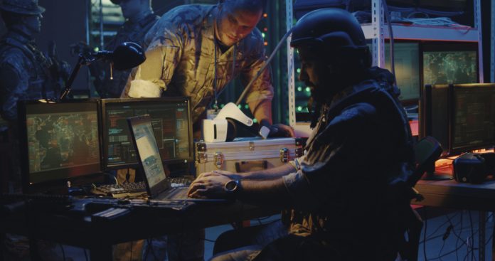 Soldiers working on computers, cyberwar concept, source: Shutterstock