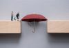 Protection gap closing concept, with figures, umbrella and wooden blocks, source: Shutterstock