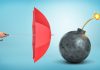 Umbrella and bomb, insurance at war times concept, source: Shutterstock
