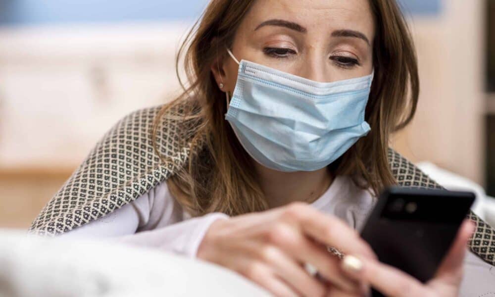 Ασθενής με μάσκα και κινητό τηλέφωνο