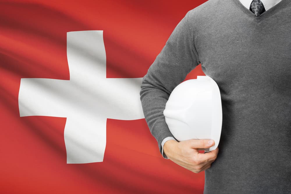 Swiss health insurance benefit conept, with flag and employee with helmet, source: Shutterstock