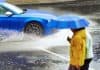 Car in heavy rain and people with umbrella, uninsured car concept, source: Shutterstock