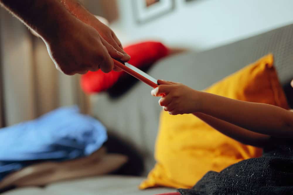 Parent taking away smartphone from child, source: Shutterstock