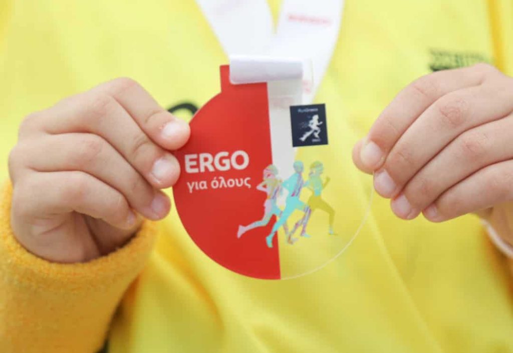 Run Greece Syros, παιδί φορά μετάλλιο με λογότυπο ERGO