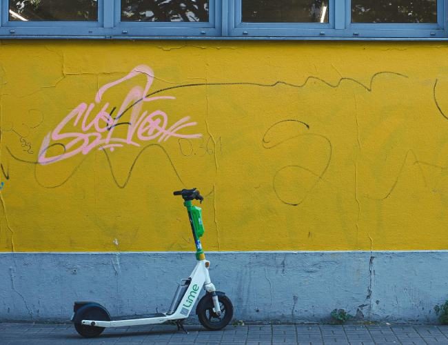 Ηλεκτρικό πατίνι μπροστά σε τοίχο με γκράφιτι, εικόνα άρθρου της wedo.insure