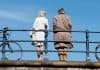 Allianz Trade pension survey cover, old man and young woman on bridge with bicycles