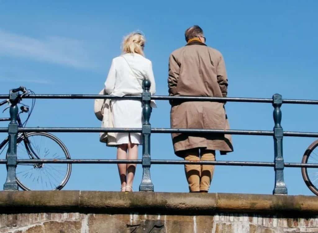 Allianz Trade pension survey cover, old man and young woman on bridge with bicycles