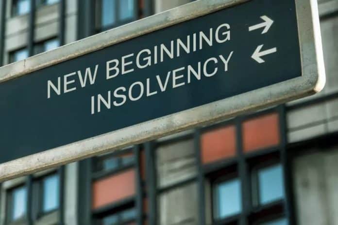 eebea52c8055-insolvencies Coface, εικόνα άρθρου για αφερεγγυότητες με σχετική ταμπέλα μπροστά σε κτίριο