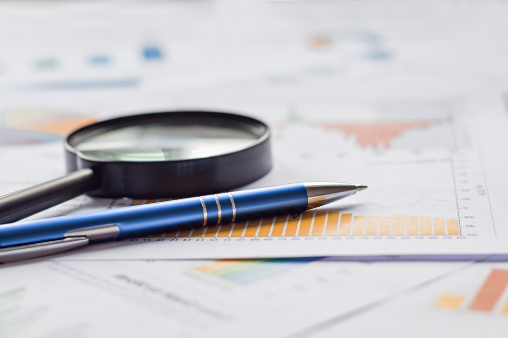 Statistics paper, magnifying glass and pen, source: Shutterstock
