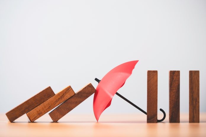 A,Red,Umbrella,Blocking,Falling,Wooden,Blocks,Symbolizing,Risk,Prevention