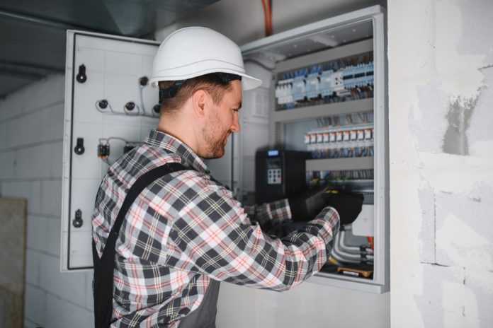 Electrician,Wearing,Safety,Helmet,Checking,Electric,Control,Panel,In,Building Ηλεκτρολόγος ελέγχει πίνακα, πηγή: Shutterstock