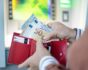 Person putting money from ATM in wallet, source: Shutterstock