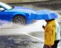 Car in heavy rain and people with umbrella, uninsured car concept, source: Shutterstock