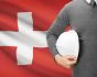 Swiss health insurance benefit conept, with flag and employee with helmet, source: Shutterstock