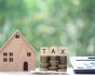 Property tax concept, model house with stack of coins and calculator, source: Shutterstock