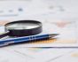 Statistics paper, magnifying glass and pen, source: Shutterstock